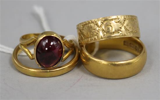 Three gold bands 22ct(2), 18ct(1) and a garnet set ring.